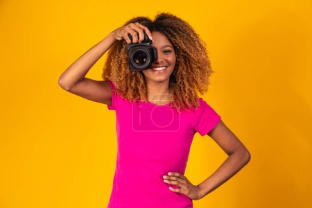 Photo for Young afro photographer making pictures with camera. - Royalty Free Image