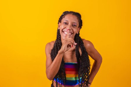 Téléchargez les photos : Jeune lesbienne noire ou bisexuelle avec le doigt dans la bouche demandant le silence - en image libre de droit