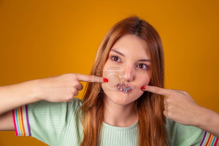 Foto de Mujer pelirroja joven con la boca con salpicaduras de colores como lápiz labial. Dulces labios jóvenes con salpicaduras - Imagen libre de derechos