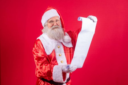 Photo for Portrait of happy Santa Claus reading Christmas letter or wish list. - Royalty Free Image