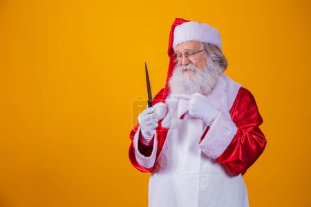 Téléchargez les photos : Le Père Noël tenant un couteau. Le mauvais concept du Père Noël. Meurtre
. - en image libre de droit