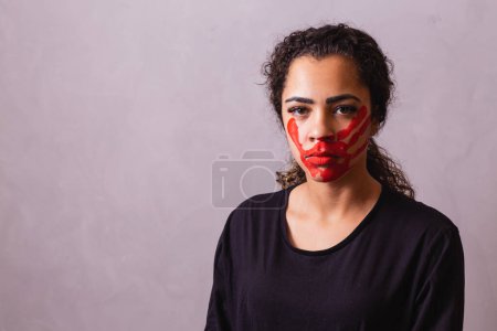 Téléchargez les photos : Femme afro avec une empreinte de main sur la bouche en faveur de la sensibilisation au féminicide. Violence domestique - en image libre de droit