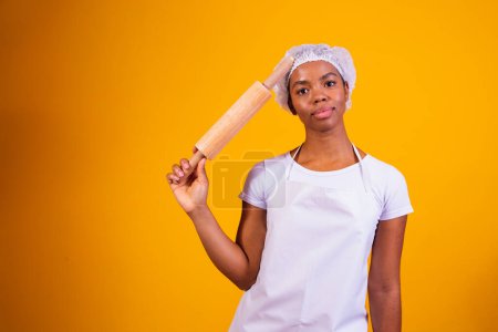 Téléchargez les photos : Jeune fille machine à pizza sur fond jaune tenant rouleau à pâtisserie. - en image libre de droit