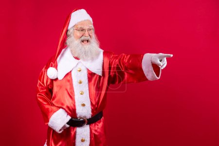 Téléchargez les photos : Père Noël pointant vers la diagonale libre pour le texte - en image libre de droit