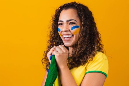 Photo for Brazilian fan with her face painted in blue and yellow for the b - Royalty Free Image