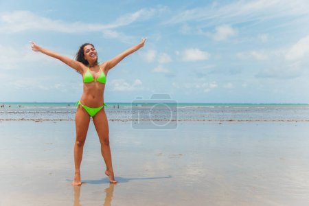 Photo for Beautiful afro brazilian woman on a beach in rio grande do norte, smiled, feeling the freedom and the waves of the sea, enjoying her summer vacation with a wonderful sun and warmth - Royalty Free Image
