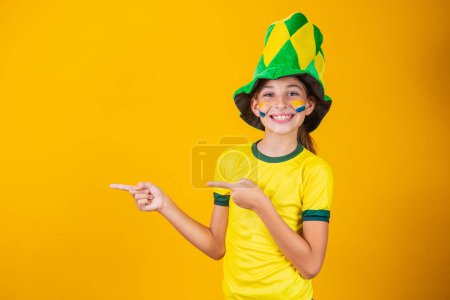Photo for Beautiful little Brazilian fan girl pointing to the side - Royalty Free Image