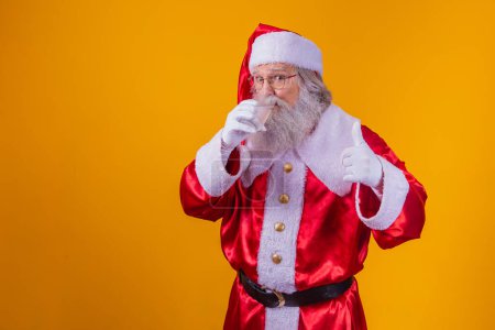 Foto de Santa Claus con agua sobre fondo amarillo. - Imagen libre de derechos