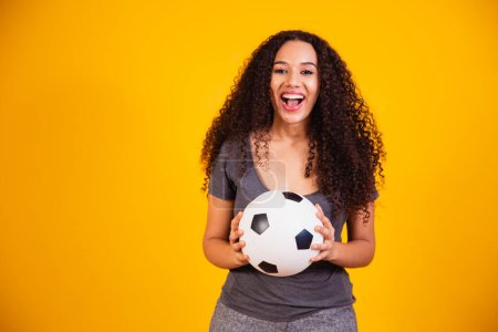 Photo for Young African American woman isolated on yellow background with soccer ball - Royalty Free Image