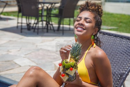 Téléchargez les photos : Jeune femme en vacances prendre une boisson à l'ananas - en image libre de droit
