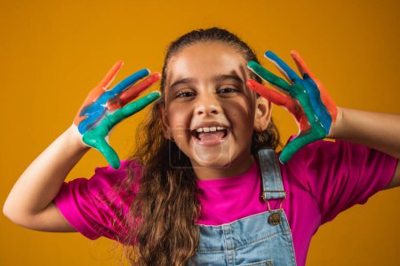 Téléchargez les photos : Une image d'une petite fille avec ses mains en peinture - en image libre de droit