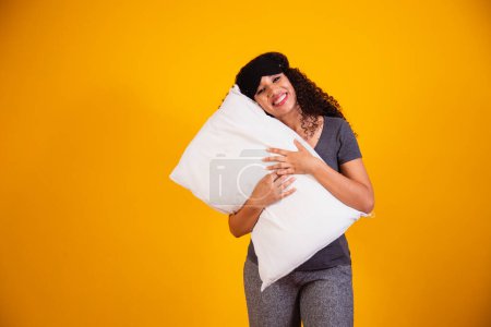 Photo for Photo of an afro girl hugging pillow on yellow background. Closeup of young girl holding a pillow in her hands. sleep concept - Royalty Free Image