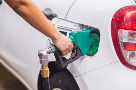 Téléchargez les photos : Ravitaillement Remplissage de voiture avec de l'essence à la station-service et pompe à essence remplissage de la buse de carburant dans le réservoir de carburant de la voiture - en image libre de droit