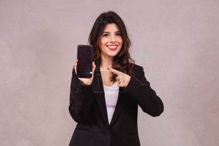 Téléchargez les photos : Portrait de femme d'affaires joyeuse montrant téléphone cellulaire sur écran vide isolé sur fond blanc. - en image libre de droit