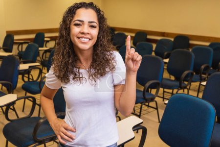 Photo for Happy young female student in the classroom with space for text. - Royalty Free Image