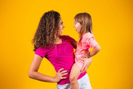 Téléchargez les photos : Joyeuse fête des mères ! Adorable enfant caucasien avec sa mère sur fond jaune. - en image libre de droit