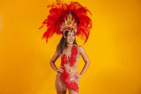 Foto de Mujer afro brasileña posando en traje de samba sobre fondo amarillo con espacio libre. Traje brasileño vestido Samba. - Imagen libre de derechos