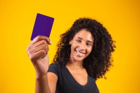 Foto de La mano de una joven sostiene la maqueta de la tarjeta púrpura. Mujer con tarjeta de compra. Hermosa joven sosteniendo tarjeta bancaria de crédito - Imagen libre de derechos
