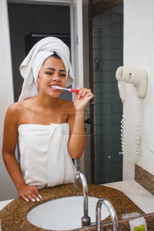 Foto de Afro mujer cepillándose los dientes en el baño - Imagen libre de derechos