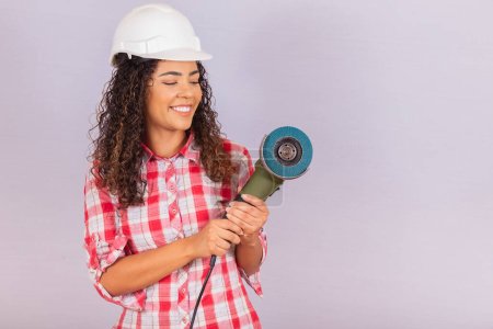 Photo for Afro woman holding an electric sander. building material concept - Royalty Free Image