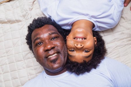 Photo for Afro father and son lying in bed - Royalty Free Image