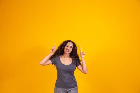 Photo for Afro woman pointing up with free space for text. - Royalty Free Image