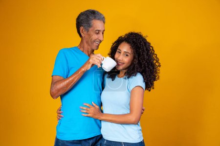 Foto de Padre con una taza de café pasando cerca de la nariz de su hija para que ella huela el aroma. Foto para el café y las campañas del Día del Padre - Imagen libre de derechos