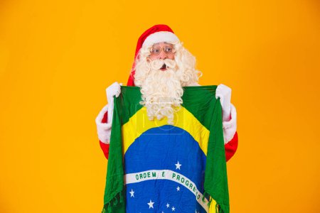 Téléchargez les photos : Le Père Noël est un fan du Brésil. Santa Claus supporter de l'équipe brésilienne. Championnat de sport. Le Père Noël tenant le drapeau brésilien. Match de football
. - en image libre de droit