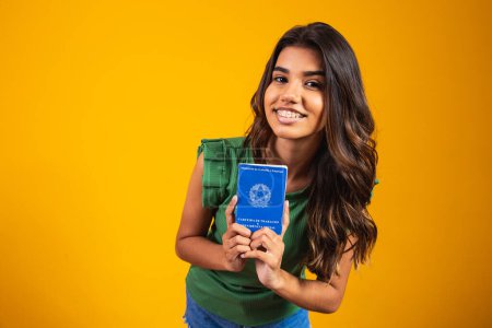Téléchargez les photos : Jeune fille tenant la carte de travail brésilienne - en image libre de droit