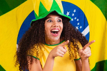 Photo for Black woman fan. Brazil colors in background, green, blue and yellow. Elections, soccer or politics. - Royalty Free Image