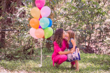 Téléchargez les photos : Heureux mère et fille dans le parc avec des ballons
. - en image libre de droit