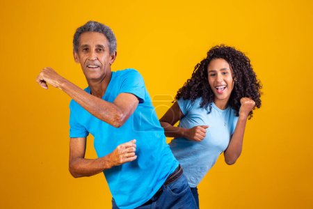 Photo for Elderly afro man with his daughter dancing. - Royalty Free Image