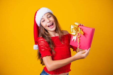 Téléchargez les photos : Excité petite fille caucasienne avec bouche ouverte tenant un cadeau de Noël. - en image libre de droit