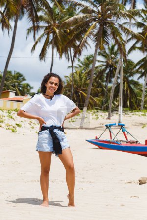 Foto de Hermosa mujer de vacaciones disfrutando al aire libre en la playa con sus pies en la arena. - Imagen libre de derechos