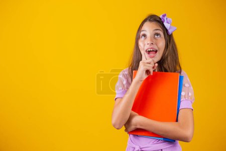 Photo for Caucasian student girl with books in her hands and her finger up. back to school - Royalty Free Image