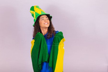 Foto de Abanico brasileño. vistiendo bandera brasileña en un retrato, ventilador brasileño celebrando fútbol o partido de fútbol en el fondo. Copa del Mundo - Imagen libre de derechos