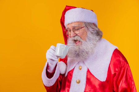 Photo for Real Santa having a coffee on yellow background with free space for text. - Royalty Free Image