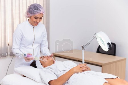 Photo for Darsonval cosmetology apparatus. Face cleaning procedure. Salon skincare treatment. Professional dermatology hardware. Electric spa equipment. Medicine patient device. Removal acne - Royalty Free Image