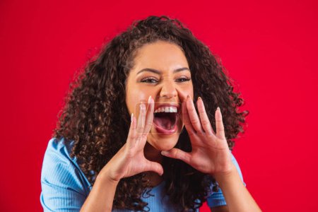 Photo for African american woman wearing a blue t-shirt over isolated red background shouting and screaming loud to side with hand on mouth. Communication concept. - Royalty Free Image