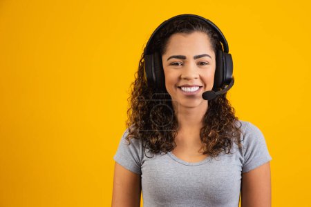 Photo for Contact the call center service. Customer support, female sales agent. Caller or operator of telephone operator or business woman in headset. Afro young woman. Zoom conference. yellow  background - Royalty Free Image