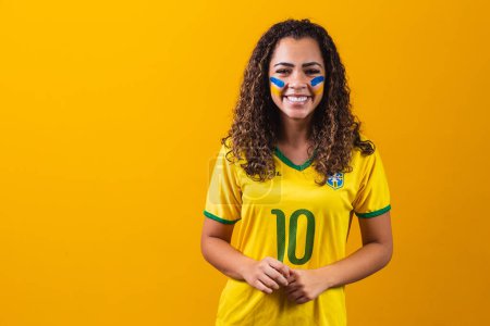 Photo for Brazilian supporter. Brazilian woman fan celebrating on soccer or football match on yellow background. Brazil colors. - Royalty Free Image