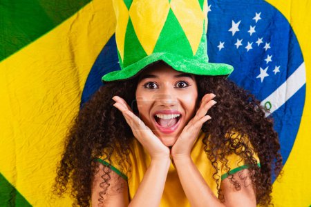 Photo for Black woman fan. Brazil colors in background, green, blue and yellow. Elections, soccer or politics. - Royalty Free Image