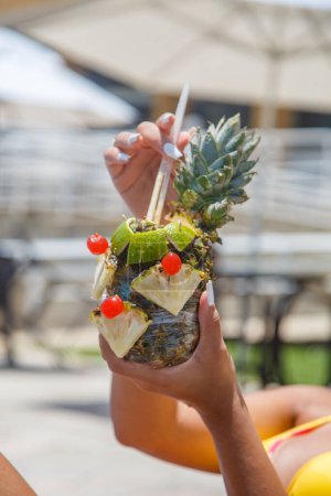 Téléchargez les photos : Gros plan de mains féminines tenant une boisson à l'ananas - en image libre de droit