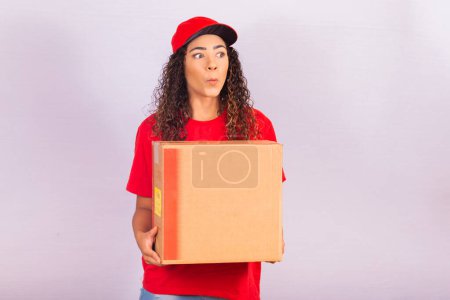 Téléchargez les photos : Femme excitée avec une boîte en carton habillée comme une fille de livraison avec un espace libre pour le texte. - en image libre de droit