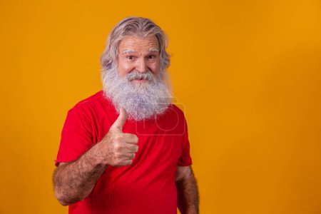 Photo for Old man with a long beard on a yellow background. Thumb up. Senior with full white beard. Old man with a long beard - Royalty Free Image