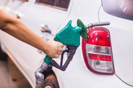 Téléchargez les photos : Ravitaillement Remplissage de voiture avec de l'essence à la station-service et pompe à essence remplissage de la buse de carburant dans le réservoir de carburant de la voiture - en image libre de droit