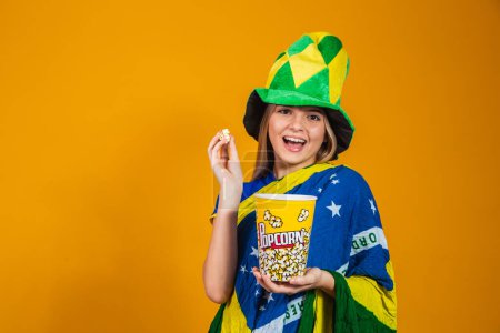 Foto de Abanico brasileño con palomitas de maíz para ver el partido. concepto de entretenimiento y deporte - Imagen libre de derechos