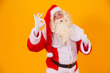 Foto de Santa Claus con una mano haciendo una señal de ok y la otra un sí por haber alcanzado la meta. - Imagen libre de derechos