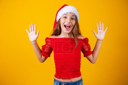 Foto de Niña emocionada por la expresiva Navidad sobre fondo amarillo. - Imagen libre de derechos