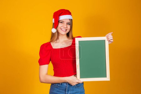 Photo for Young blonde dressed for christmas holding a placard. Christmas - Royalty Free Image